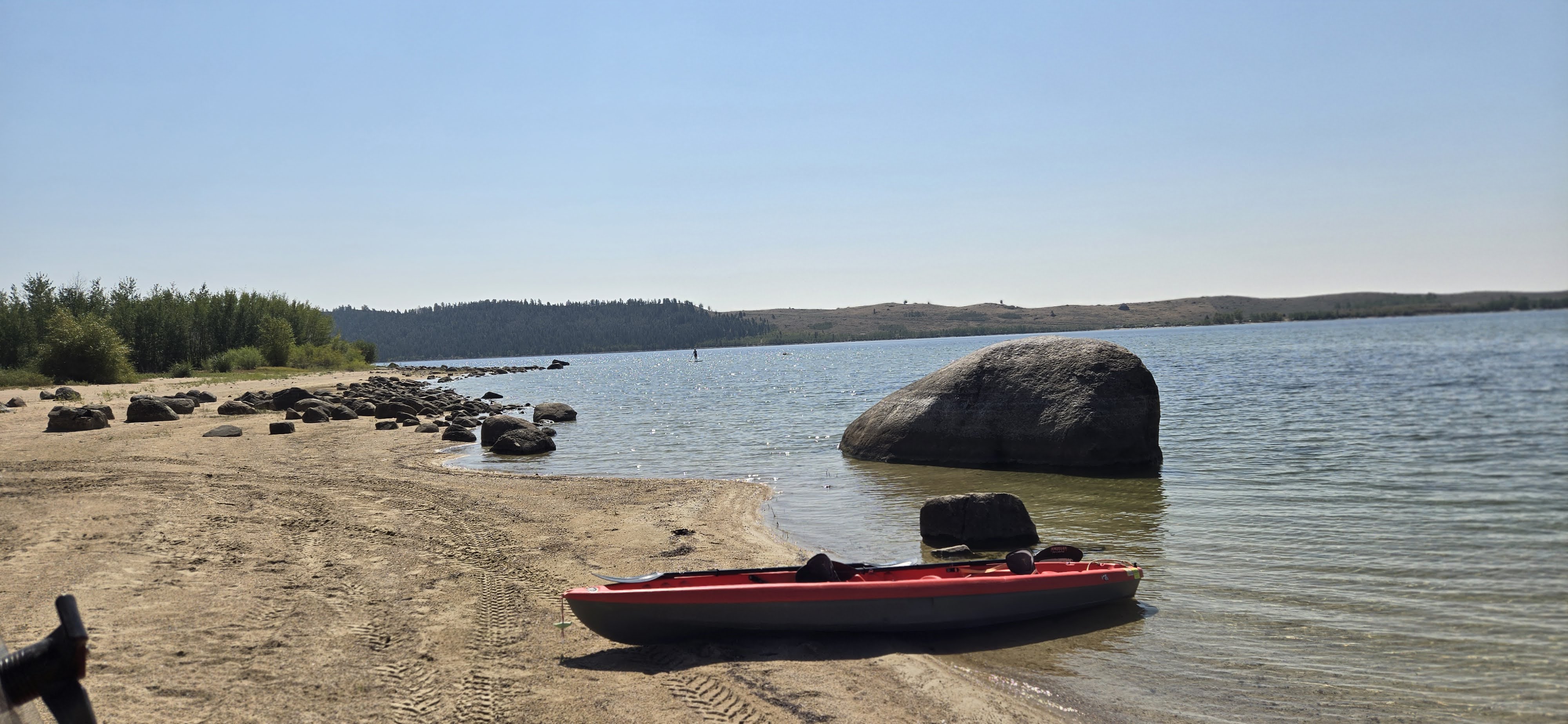 Sandy lakeshore with mountain views